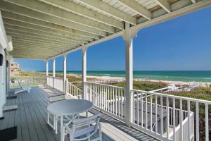 a porch with a table and chairs and the beach at King's Crown in St. George Island