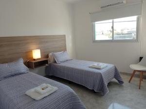 a bedroom with two beds and a window at Alojamientos Litoral - 1 B in Gualeguaychú