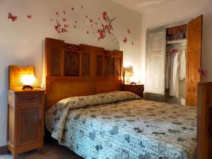 a bedroom with a large bed with a wooden headboard at Il gioco dell'oca in Ponna Superiore