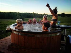 Unique Countryhouse & Sauna in Gauja Valley - Kaķukalns في Straupe: مجموعة من الناس في حوض استحمام ساخن