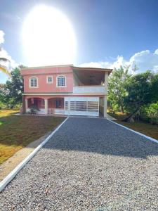 a large pink house with a gravel driveway at Bongo Lodge in Las Galeras