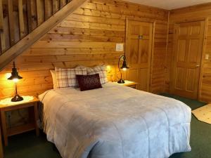 um quarto com uma cama num chalé de madeira em Susitna River Lodging, Suites em Talkeetna