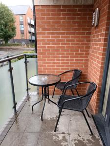 une table et deux chaises assises sur une terrasse dans l'établissement Ground Floor Apartment Private Parking Sleeps 5 near City Centre and Shopping Centre, à Birmingham