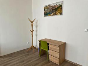 un escritorio con una silla verde y una pintura en la pared en Grand apartments in the centre of Teplice en Teplice