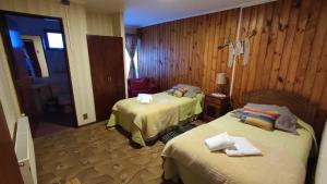 a hotel room with two beds in a room at Hostal Los Pinos in Puerto Natales