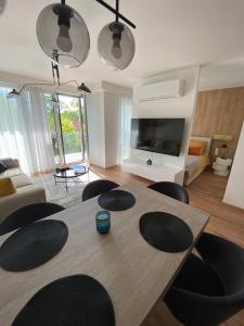 sala de estar con mesa de madera y sillas en Premium Lelle Waterfront Resort Clyde, en Balatonlelle