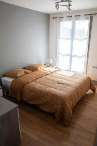 a bed in a bedroom with a large window at Lorraine in Mantes-la-Jolie