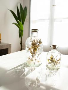 dos jarrones de cristal con flores en una mesa en Lorraine, en Mantes-la-Jolie