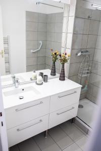een badkamer met een witte wastafel en een spiegel bij Lorraine in Mantes-la-Jolie