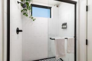 a bathroom with a shower with a glass door at The Brick Boutique Hotel in Oceanside