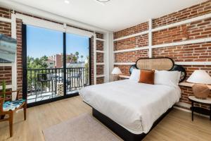 a bedroom with a brick wall and a bed and a window at The Brick Boutique Hotel in Oceanside