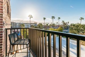 a chair sitting on a balcony with palm trees at The Brick Boutique Hotel in Oceanside
