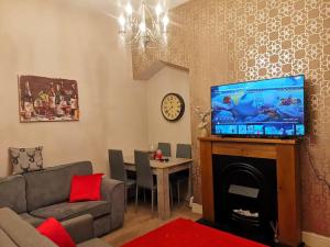 a living room with a couch and a fireplace with a tv at Sommerset Cottages - 2 BR House in Sunderland