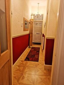 einen Flur mit einer roten Wand und einer weißen Tür in der Unterkunft Sommerset Cottages - 2 BR House in Sunderland