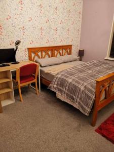 a bedroom with a bed and a desk with a laptop at Sommerset Cottages - 2 BR House in Sunderland