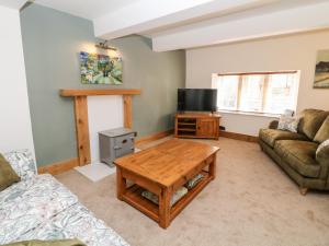 a living room with a couch and a tv at The Old Cobblers in Hayfield