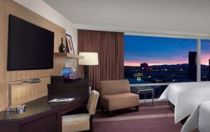 a hotel room with a bed and a desk and a television at ARIA Resort & Casino in Las Vegas