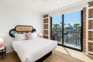 a bedroom with a bed and a large window at The Brick Boutique Hotel in Oceanside
