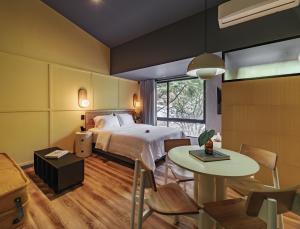 um quarto de hotel com uma cama e uma mesa em The Somos Flats Provenza em Medellín
