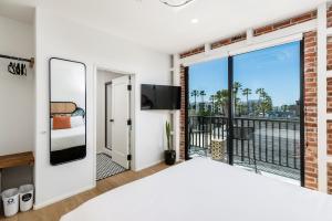 a bedroom with a balcony with a view of the ocean at The Brick Boutique Hotel in Oceanside