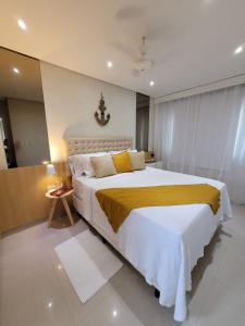 a bedroom with a large bed with a yellow blanket at Casa Flórida in Aquiraz