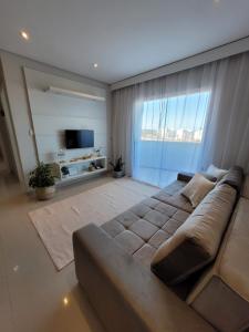 ein Wohnzimmer mit einem Sofa und einem großen Fenster in der Unterkunft Casa Flórida in Aquiraz
