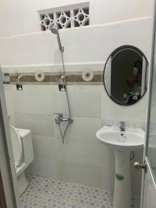 y baño con lavabo, espejo y aseo. en Gia lai Homestay Phương My en Pleiku