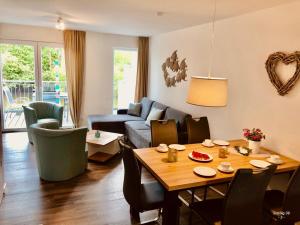 ein Wohnzimmer mit Tisch und Couch in der Unterkunft Familienhaus an der Nordsee - Sauna - Kamin - Südterrasse direkt über dem Wasser in Wangerland