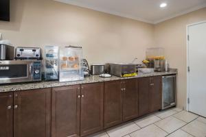 a kitchen with wooden cabinets and a counter with a microwave at Best Western - McKenzie in McKenzie