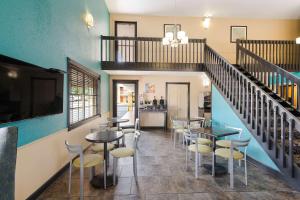 a restaurant with tables and chairs and a staircase at Best Western Conway in Conway
