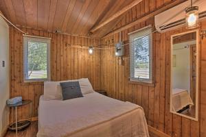 ein Schlafzimmer mit einem Bett in einer Holzwand in der Unterkunft half Mi to Dtwn! Suttons Bay Waterfront Cottage in Suttons Bay