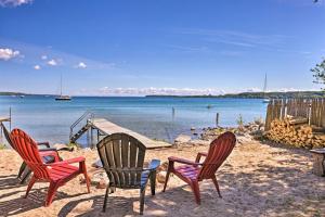 eine Gruppe von vier Stühlen am Strand in der Unterkunft half Mi to Dtwn! Suttons Bay Waterfront Cottage in Suttons Bay