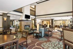 a hotel lobby with tables and chairs and a fireplace at Sonesta ES Suites San Diego - Rancho Bernardo in Rancho Bernardo