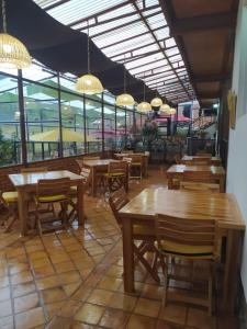 a restaurant with wooden tables and chairs and windows at HOTEL BOUTIQUE 14 LANCEROS in Paipa