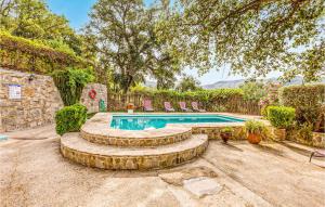 a swimming pool in a yard with chairs and a tree at Cozy Home In Algatocin With Kitchenette in Algatocín