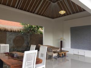 comedor con mesa y sillas blancas en Pranajaya loka 2 bed rooms villa, en Tejakula