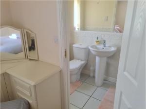 a white bathroom with a toilet and a sink at Stunning 4-Bed House in Walsall in Walsall