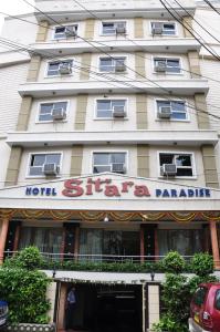 a hotel with a sign in front of a building at Sitara Paradise in Hyderabad