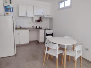 a kitchen with a white table and white chairs at DTo CÉNTRICO LOBOS PB in Lobos