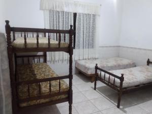 two bunk beds in a room with two beds at Casa Imponente Vila Atlântica - Beira Mar in Mongaguá