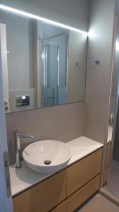 ein Badezimmer mit einem weißen Waschbecken und einem Spiegel in der Unterkunft Caltabania Suites in Agios Nikitas