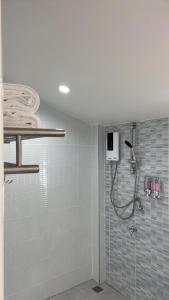 a shower in a bathroom with blue tiles at Cozy life ไออุ่น in Khao Kho