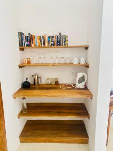 a room with wooden shelves with books at Nyumba Nyekundu in Watamu