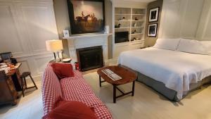 a bedroom with a bed and a fireplace and a couch at Dot's Landing Garden Room in Niagara on the Lake