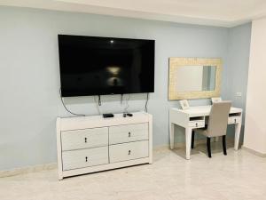 a living room with a desk and a television on a wall at Noè Hotel 1 king bedroom # 10 in Punta Cana