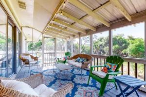 a screened in porch with chairs and a table at Our Anchor in St. George Island