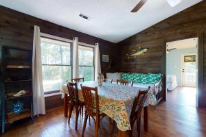a dining room with a table and chairs and a bed at Our Anchor in St. George Island