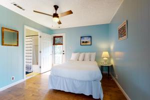 a bedroom with a white bed and a ceiling fan at Our Anchor in St. George Island