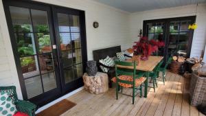 a porch with a table and chairs on a deck at Dot's Landing Garden Room in Niagara on the Lake