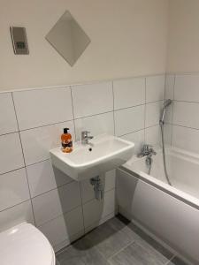 a bathroom with a sink and a toilet and a tub at Home From Home Cosy 2 Bed Apartment in Bradford